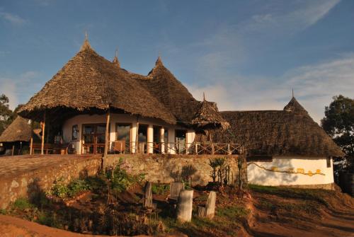 una casa con techo de paja en un campo en Mambo View Point, en Ndungu