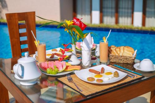 a table with plates of breakfast food on it at Mount Marina Villas 12 in Galle