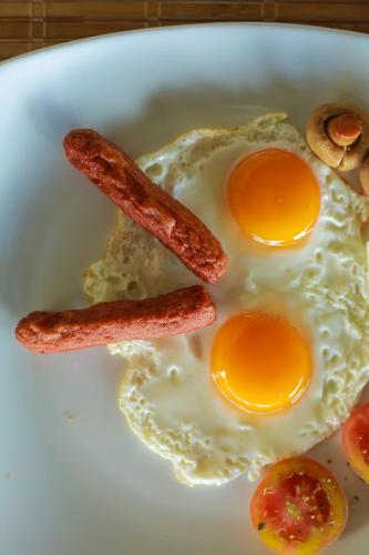 two fried eggs and bacon on a white plate at Mount Marina Villas 12 in Galle