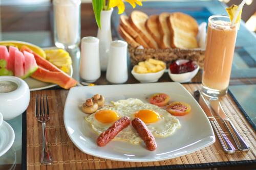 a breakfast plate with eggs and sausage on a table at Mount Marina Villas 12 in Galle