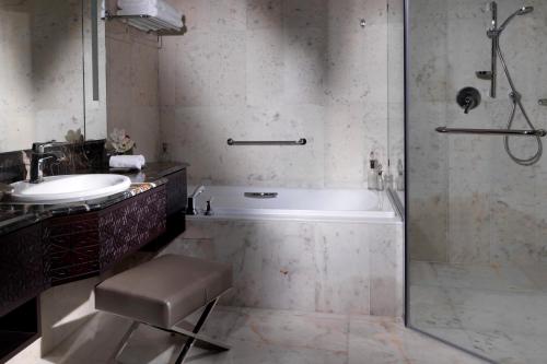 a bathroom with a tub and a sink and a shower at Bab Al Qasr Hotel in Abu Dhabi