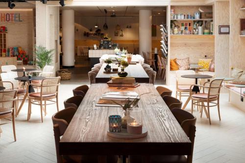 a restaurant with a long wooden table and chairs at Best Western Plus Hotel Noble House in Malmö