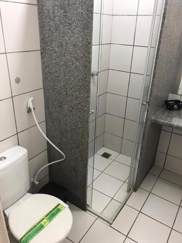a bathroom with a toilet and a glass shower at Hotel Cajuína Sul in Teresina