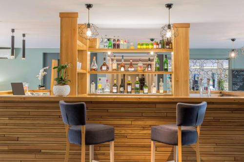 a bar with two chairs in front of a counter at Best Western Plus Hyères Côte D'Azur in Hyères