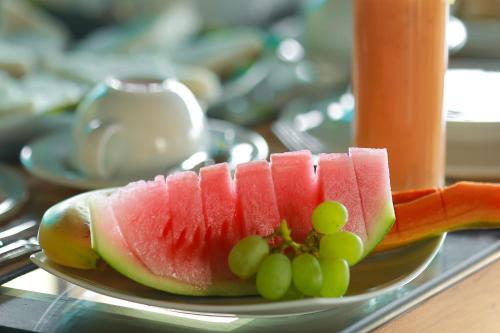 a plate of watermelon and grapes on a table at Mount Marina Villas 12 in Galle