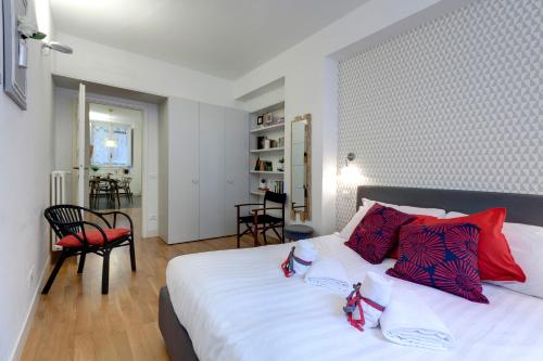 sypialnia z dużym białym łóżkiem z czerwonymi poduszkami w obiekcie Costa San Giorgio Apartment by Mamo Florence we Florencji