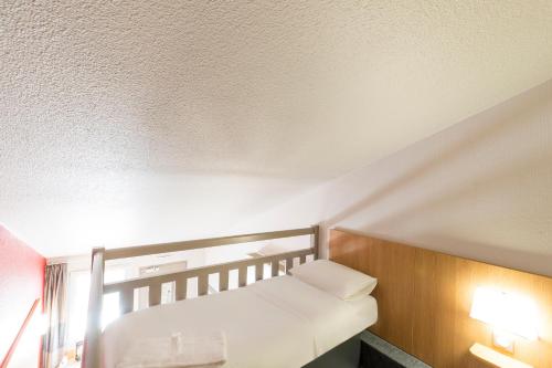 Ένα ή περισσότερα κρεβάτια σε δωμάτιο στο B&B HOTEL Auxerre Bourgogne