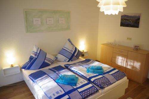 1 dormitorio con 1 cama con almohadas azules y blancas en Ferienwohnung CaTi, en Immenstadt im Allgäu