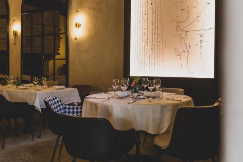 a dining room with two tables with wine glasses at Mercure Figeac Viguier du Roy in Figeac