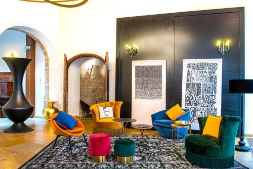 a room with colorful chairs and tables in it at Mercure Figeac Viguier du Roy in Figeac