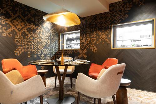 a dining room with orange chairs and a table at Hotel Le Chabichou in Courchevel