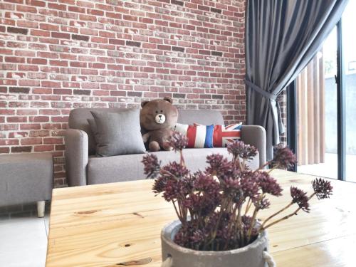 a teddy bear sitting on a couch in a living room at 23Loft Kuching in Kuching
