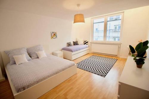 a bedroom with a bed and a couch and a window at Fantastic Apartment in Enchanting Neighbourhood in Ludwigshafen am Rhein
