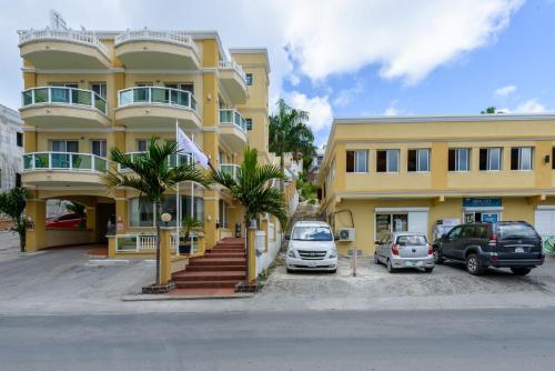 a yellow building with cars parked in front of it at Baker's Suites in Simpson Bay