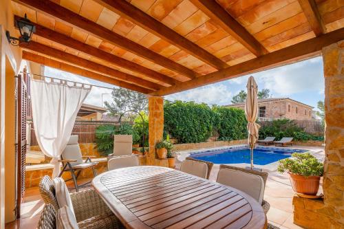 a patio with a table and a swimming pool at Villa Portals Nous by Priority in Portals Nous
