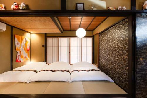1 dormitorio con 1 cama en una habitación en 京町屋の宿悠路里 Kyo-Machiya YululY en Kioto