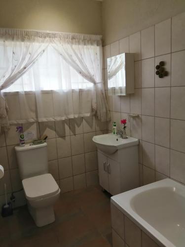 a bathroom with a toilet and a sink and a tub at Eden Cottage in White River