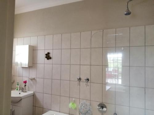 a bathroom with a shower and a toilet and a sink at Eden Cottage in White River