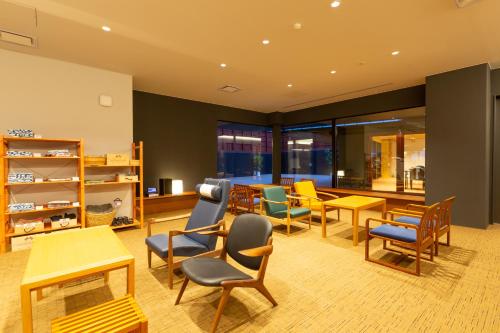 a waiting room with colorful chairs and tables at Iseya, Seaview Private Oceanside Bath in Unzen