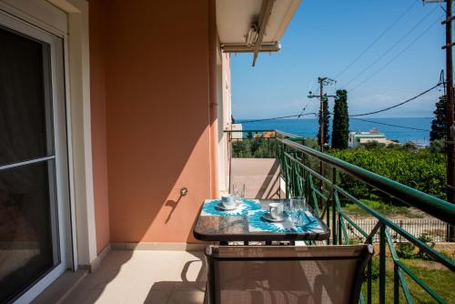 a table on a balcony with a view at Lovely Apartment Next to the Sea Lygia Korinthias in Liyiá