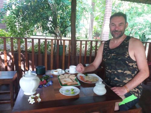 a man sitting at a table with a plate of food at Heaven in Satinwoods in Tangalle