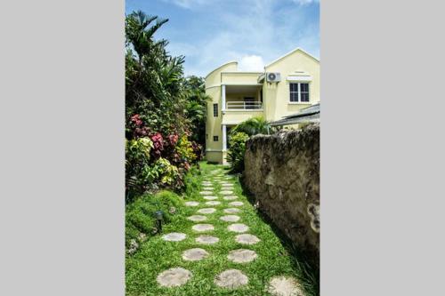 a stone path leading to a house at Vida Mejor - Poolside in Saint James