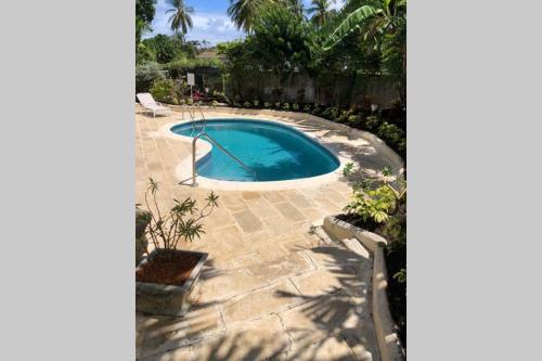 a small swimming pool in a yard with a patio at Vida Mejor - Poolside in Saint James