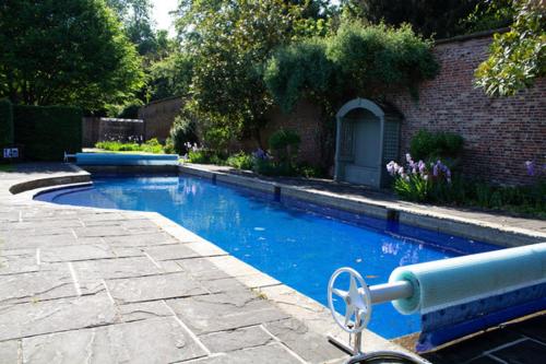 una piscina en un patio junto a una casa en Saltmarshe Hall, en Saltmarshe