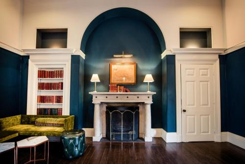 a living room with a fireplace and a blue wall at Saltmarshe Hall in Saltmarshe