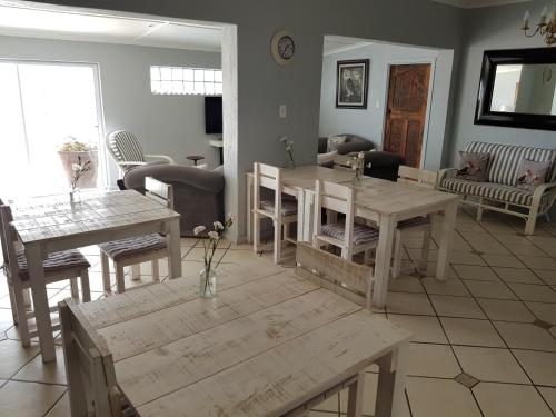 a living room with wooden tables and chairs at Beachcombers in Agulhas