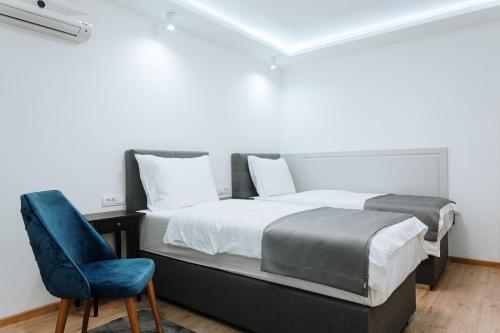 a bedroom with a bed and a blue chair at Boutique Hotel Nea in Brčko