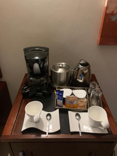 a table with utensils and a coffee maker on it at Royal Hotel in Polokwane