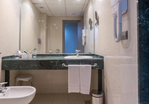 a bathroom with a sink and a mirror at Hotel Olympia Valencia in Alboraya