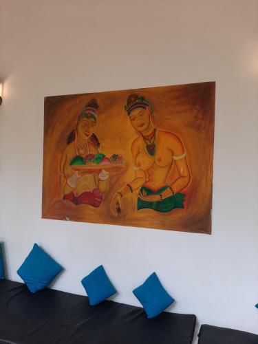 a painting of two women on a wall at Omeesha Beach Hotel in Kalpitiya