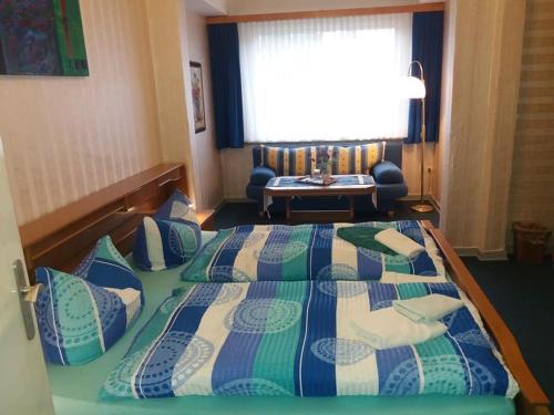a hotel room with a large bed and a table at Pension Cecilie in Braunlage