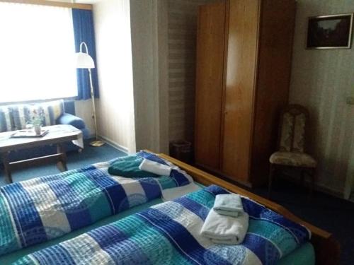 a bedroom with a bed with towels on it at Pension Cecilie in Braunlage