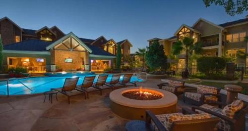 a backyard with a pool with chairs and a fire pit at Resort Style Apartment/Home - The Woodlands in The Woodlands