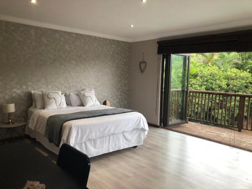 a bedroom with a bed and a balcony at Number Six in Durban