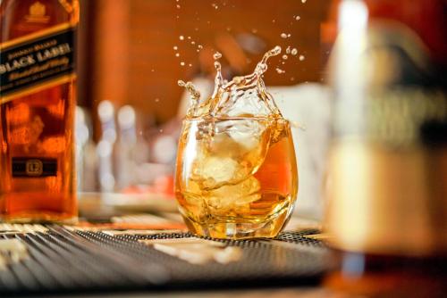 a glass of whiskey sitting on a table at Mayur Hotel Bar And Restaurant in Solan