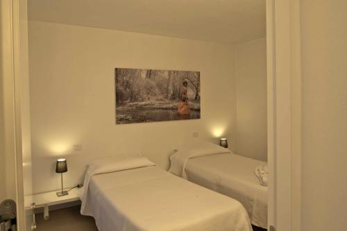 フェルトレにあるCasa Esterのベッド2台が備わる客室で、壁には絵画が飾られています。