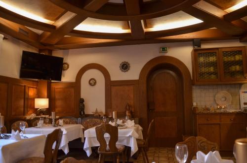 a dining room with tables and chairs and a tv at Hotel Restaurant Lamm in Mönsheim