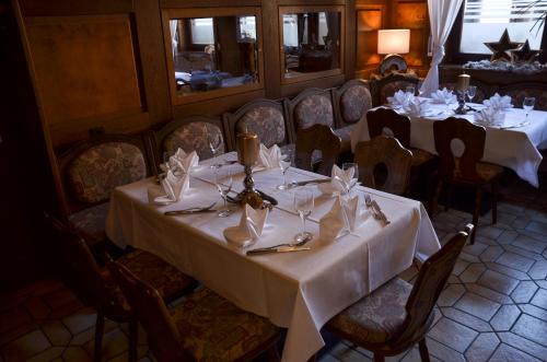a dining room with tables with white tablecloths at Hotel Restaurant Lamm in Mönsheim