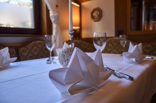 a table with a white table cloth with wine glasses at Hotel Restaurant Lamm in Mönsheim
