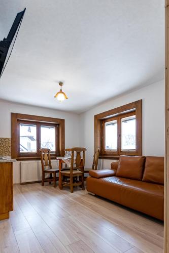 a living room with a couch and a table at Apartamenty i pokoje Pod Limbami - sauna, tężnia in Bukowina Tatrzańska