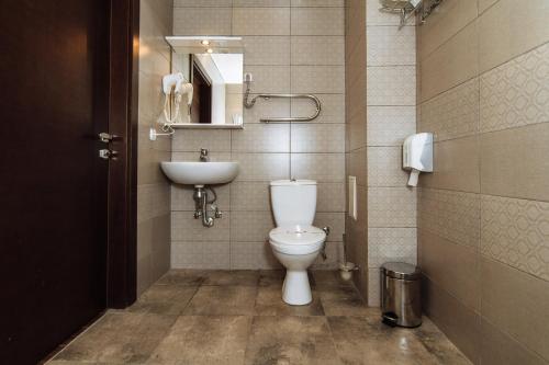 een badkamer met een wit toilet en een wastafel bij Congress Hotel Verhovina in Kiev