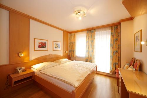 Un dormitorio con una cama grande y una ventana. en Apartment Sonnenblume Kusenberg, en Schladming