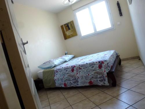 a small bedroom with a bed and a window at Central Montgaillard in Saint-Denis