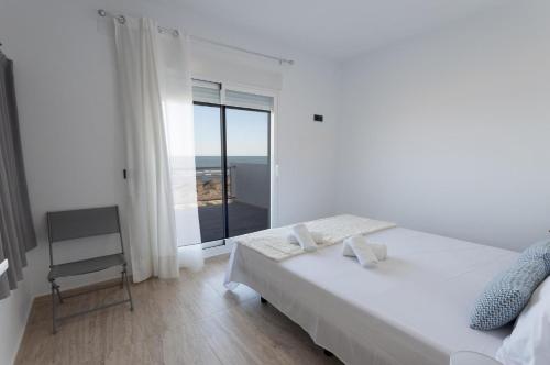a bedroom with a bed and a view of the ocean at Vistamar 1 in Oliva