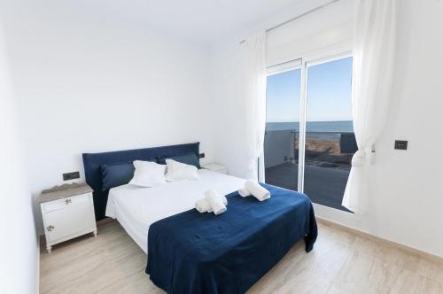 a bedroom with a bed and a large window at La Mar de Olas in Oliva