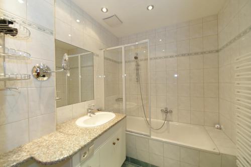 Un baño con lavabo, ducha y bañera. en Apartment Sonnenblume Kusenberg, en Schladming